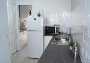a kitchen with a white refrigerator and a microwave at Maude St Apartments in Shepparton