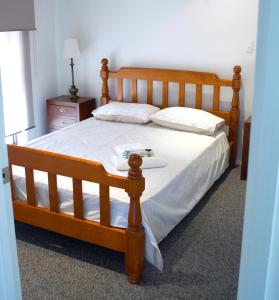 ein Schlafzimmer mit einem Holzbett mit einem Tablett darauf in der Unterkunft Maude St Apartments in Shepparton