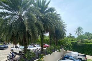 a group of cars parked in a parking lot with palm trees at Lux apartments TOP in Koh Samui