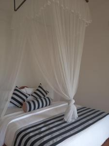 a bed with black and white pillows and a canopy at Saddle Cottage in Ella +61 photos