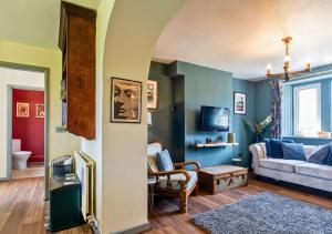 a living room with blue walls and a couch at Gorgeous Rural 4 Bed Farm Cottage - With Hot Tub! in Norton Saint Philip