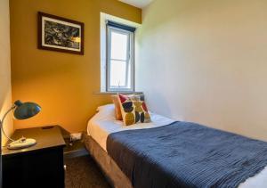 a bedroom with a bed and a desk and a window at Gorgeous Rural 4 Bed Farm Cottage - With Hot Tub! in Norton Saint Philip