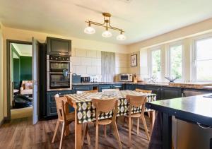 a kitchen with a table and chairs in it at Gorgeous Rural 4 Bed Farm Cottage - With Hot Tub! in Norton Saint Philip
