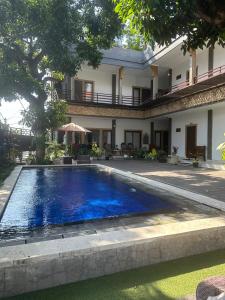 ein Swimmingpool vor einem Haus in der Unterkunft Pudak Sari Homestay in Kuta