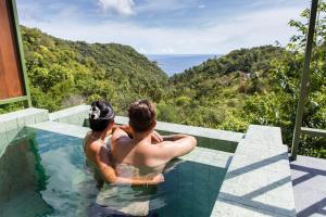 ein Mann und eine Frau sitzen in einem Swimmingpool in der Unterkunft Mae Ya Resort in Ko Tao