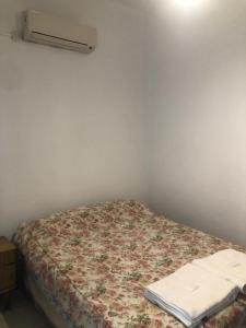 a small bedroom with a bed with a floral blanket at El Solaz en la Ciudad in San Juan