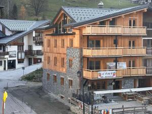 a large wooden building with balconies on the side of it at Appartement cosy 3 pièces, pied des pistes, parking, Pralognan - FR-1-464-242 in Pralognan-la-Vanoise