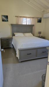 a bedroom with a large bed and a window at King's place in Old Harbour