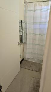 a bathroom with a shower with a shower curtain at King's place in Old Harbour +7 photos