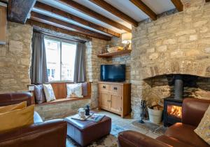 a living room with a stone wall with a fireplace at Diston's Lane - Beautiful 2BD Home, Perfect For Family Retreat! in Chipping Norton