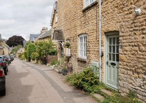 a brick building with a green door on a street at Diston's Lane - Beautiful 2BD Home, Perfect For Family Retreat! in Chipping Norton