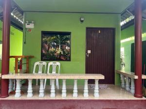 a bench in a room with a green wall at ABC Bungalow in Ban Tai