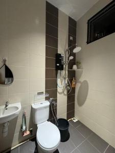 a bathroom with a white toilet and a sink at Stylaa Homestay Kedah in Kampong Guar Nanas +35 photos