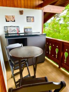 a small table and chairs on a balcony with a desk at Apartamento Bierbaum in Treze Tílias +9 photos