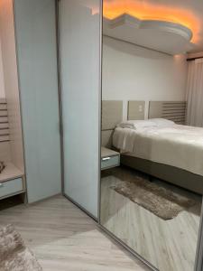 a mirror in a room with a bed and a bedroom at Apartamento Bierbaum in Treze Tílias