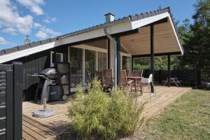 un padiglione con tavolo e sedie su una terrazza di Awesome Home In Ebeltoft With 3 Bedrooms, Sauna And Wifi a Ebeltoft