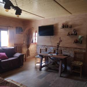 un soggiorno con tavolo e TV a parete di Casa Haza San Luis a Riópar Altre 12 foto