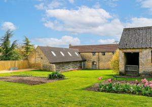 an old stone house with a yard with flowers at Glyme Flat - Peaceful Country Retreat! in Chipping Norton