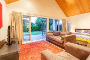 un salon avec un canapé et un lit dans l'établissement Lake Okareka Cottage, à Rotorua