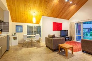 un salon avec un canapé et une table dans l'établissement Lake Okareka Cottage, à Rotorua