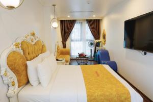 a hotel room with a bed and a flat screen tv at Royal Hotel Thanh Trì in Hanoi