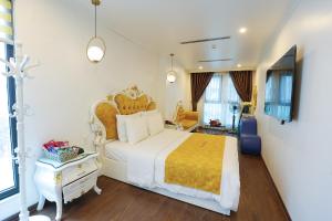 a bedroom with a large bed with a yellow blanket at Royal Hotel Thanh Trì in Hanoi