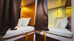two beds in a small room with a mirror at Pathfinder's Nest Hostel in Darjeeling