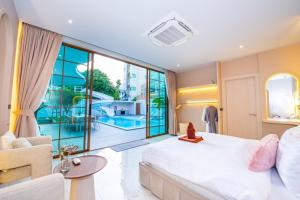 a bedroom with a large bed and a living room at Paco Villa Pattaya in Jomtien Beach +70 photos