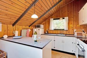 a kitchen with white cabinets and a counter with wine glasses at Charming Older House With A Hot Tub in Knebel +13 photos