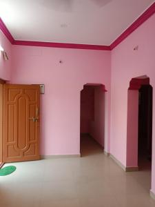 Una habitación vacía con paredes rosas y una puerta de madera. en Sri arunachala shiva homestay 2, en Tiruvannāmalai
