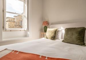 ein Schlafzimmer mit einem weißen Bett und einem Fenster in der Unterkunft Hitchmans Mews - Stunning 2BD in Chipping Norton! in Chipping Norton