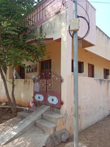 Un edificio con una puerta roja y escaleras al frente. en Sri arunachala shiva homestay 2, en Tiruvannāmalai