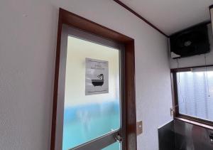 a glass door in a room with a window at apartment hotel myu 宇都宮 in Utsunomiya