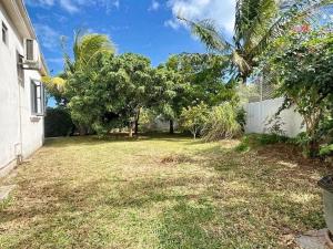 a yard of a house with trees and a fence at N'joy Pereybere Villa in Pereybere