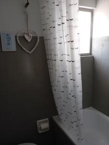 a bathroom with a shower curtain with birds on it at Comfy Studio in Lamía
