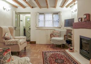 a living room with a fireplace and a tv at Honeypot Cottage - Charming Bolthole in Stow! in Stow on the Wold