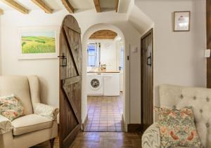 a living room with a door leading to a kitchen at Honeypot Cottage - Charming Bolthole in Stow! in Stow on the Wold