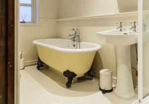 a bathroom with a tub and a sink at Honeypot Cottage - Charming Bolthole in Stow! in Stow on the Wold +38 photos