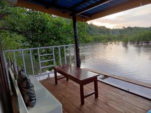 un banc sur une terrasse avec vue sur un lac dans l'établissement Charitas cottage, à Nuhu Tawun 11 autres photos
