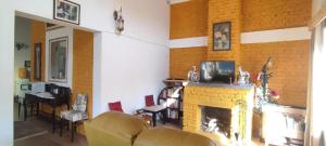 a living room with a fireplace and a tv at Katie's Abode, Hartola in Rāmgarh