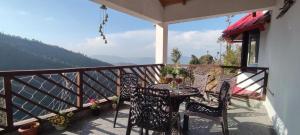 a patio with a table and chairs on a balcony at Katie's Abode, Hartola in Rāmgarh +25 photos