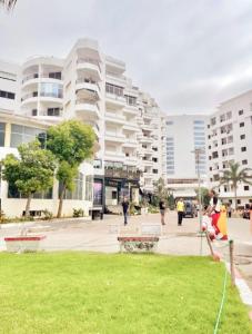 a park in front of a large apartment building at Cozy Flat With Sea View in Tangier