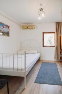 a bedroom with a white bed and a blue rug at AlmaVille Mamaia in Mamaia Sat/Năvodari
