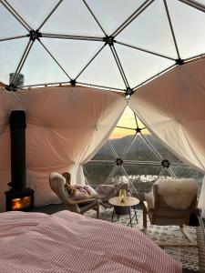 una donna sdraiata su un letto in una tenda di Handeland Lodge I Arctic Dome a Sauda