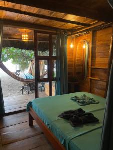 a bedroom with a bed and a window with a view at Chill and Surf Mendihuaca in Santa Marta