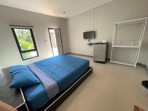 een slaapkamer met een blauw bed en een televisie bij คุณเก้า รีสอร์ท in Non Sa-at