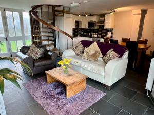 多尔盖罗Cader Mountain View Cottage with Hot Tub in Snowdonia的客厅配有白色沙发和茶几