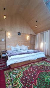 a bedroom with a large bed and a large rug at Sukoon Saath by Hostalgic in Jibhi