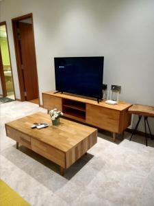 sala de estar con TV de pantalla plana y mesa de centro en Sky Suites KLCC by KD Sky Home, en Kuala Lumpur