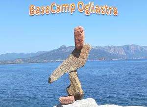 una statua di roccia davanti a un corpo d'acqua di BaseCamp Ogliastra - House a Santa Maria Navarrese